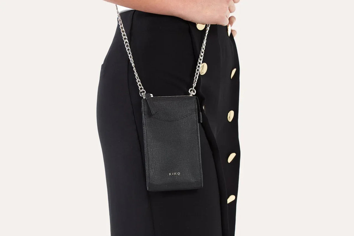 Adjustable and removable shoulder strap attached to pink crossbody phone wallet.
