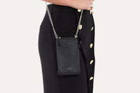 Adjustable and removable shoulder strap attached to pink crossbody phone wallet.
