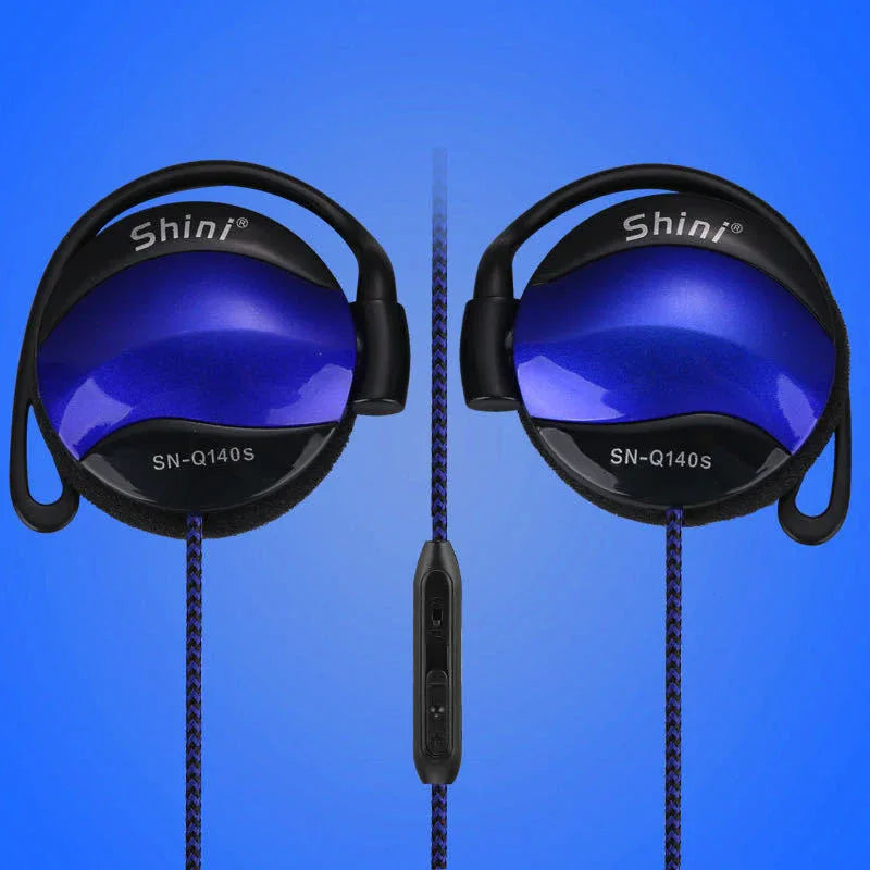 Black ear hook headphone worn on model's ear, showing fit and microphone placement.