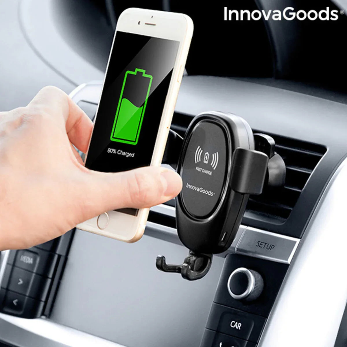 Close-up of wireless car phone holder gripping mobile device, charging icon visible on phone screen.