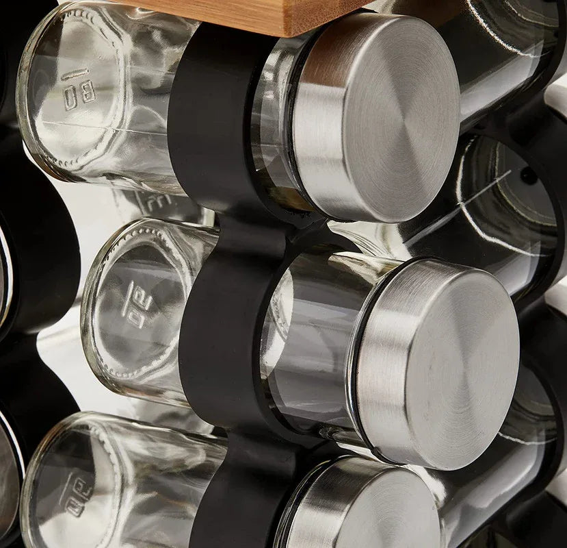 Modern stainless steel spice rack organizer with jars displaying various spices inside.