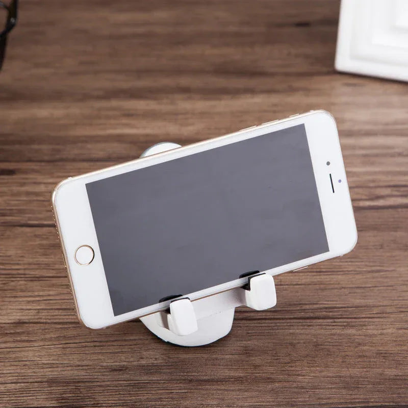 Front view of resin astronaut phone stand holding a black smartphone.