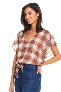 Close-up of plaid pattern and flutter sleeve detail on tie-front blouse.