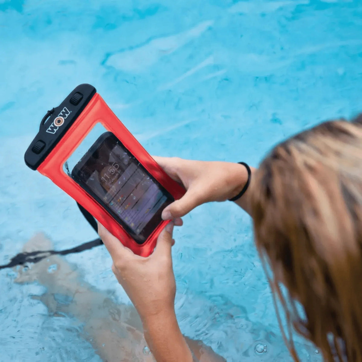 Person placing a smartphone inside the WOW Watersports waterproof phone holder.