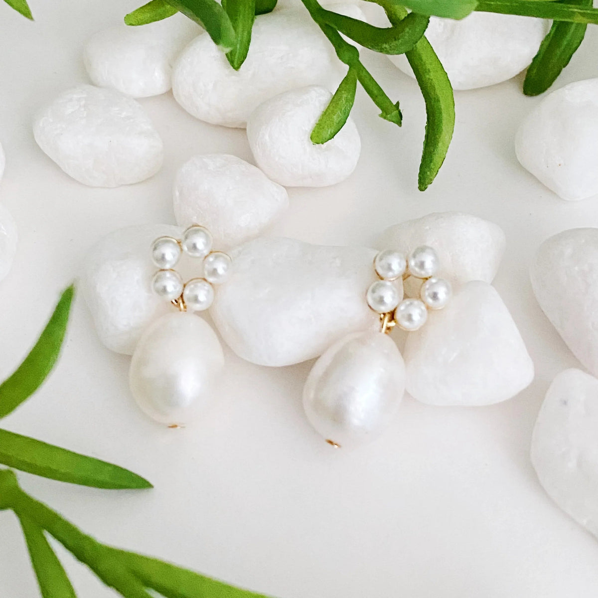 Close-up of circular pearl bead arrangement on a gold-plated drop earring.