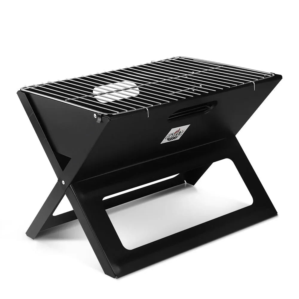 Compact portable charcoal BBQ grill on wooden surface with lid closed