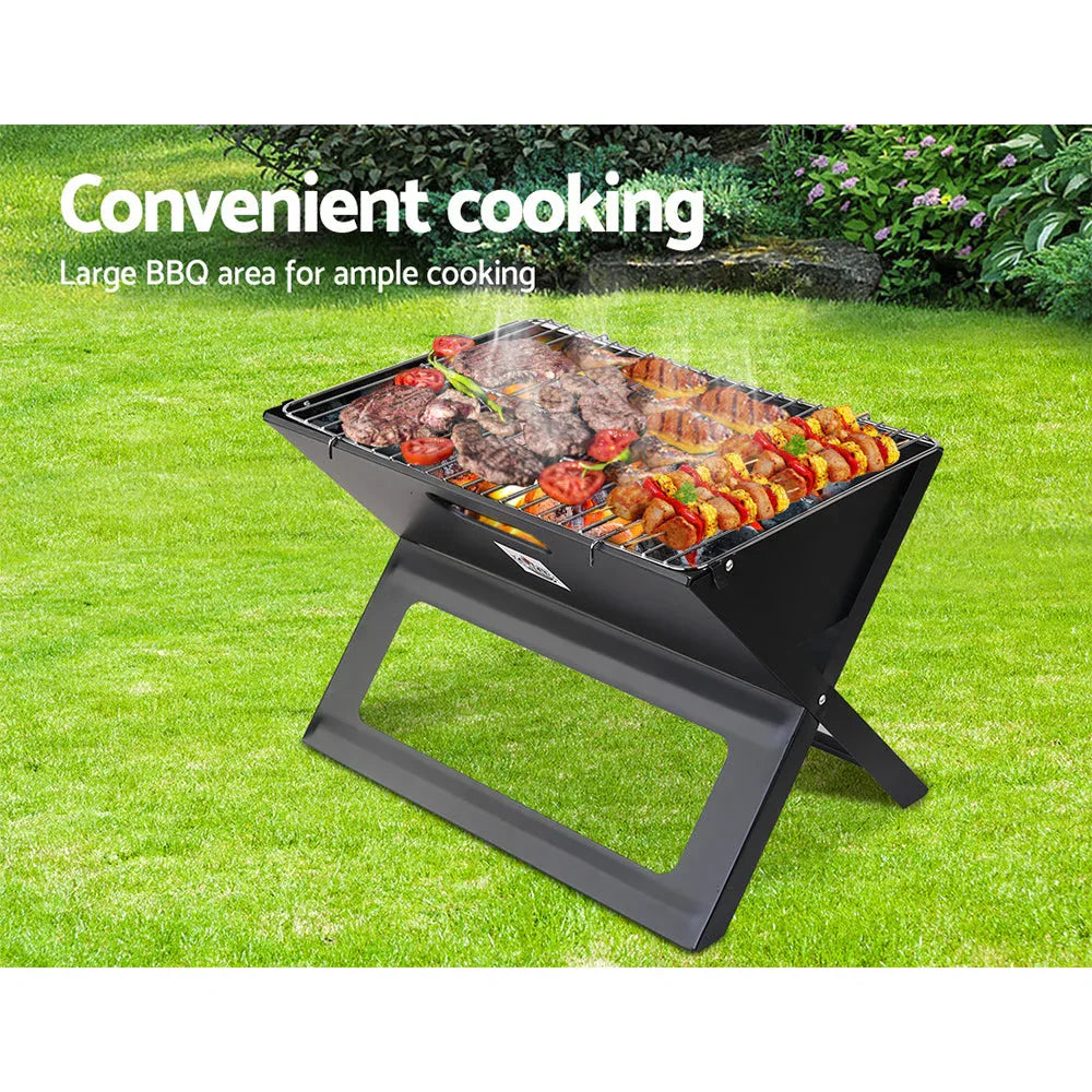 Close-up of grilling meat over glowing charcoal inside portable BBQ grill