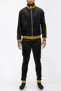 Close-up of black and gold velour track jacket showing fabric texture and zipper details.