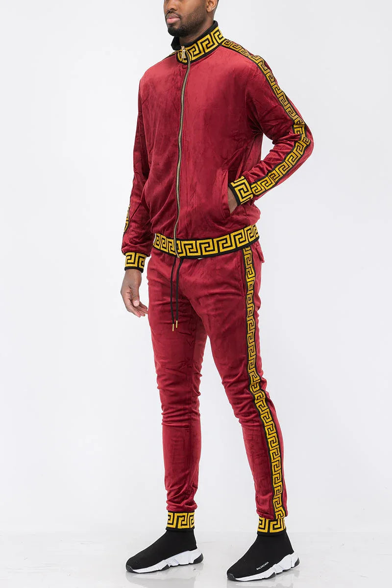 Burgundy velour track jacket and pants laid out flat showing details and color contrast.