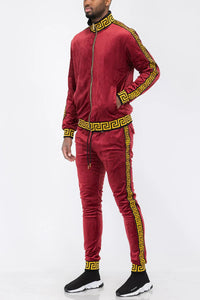 Burgundy velour track jacket and pants laid out flat showing details and color contrast.