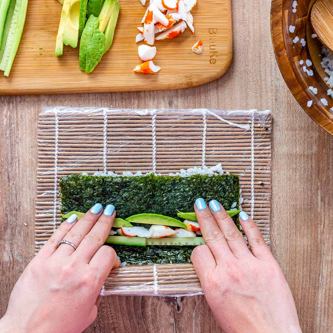 Single bamboo sushi rolling mat displayed flat on a rustic wooden surface.