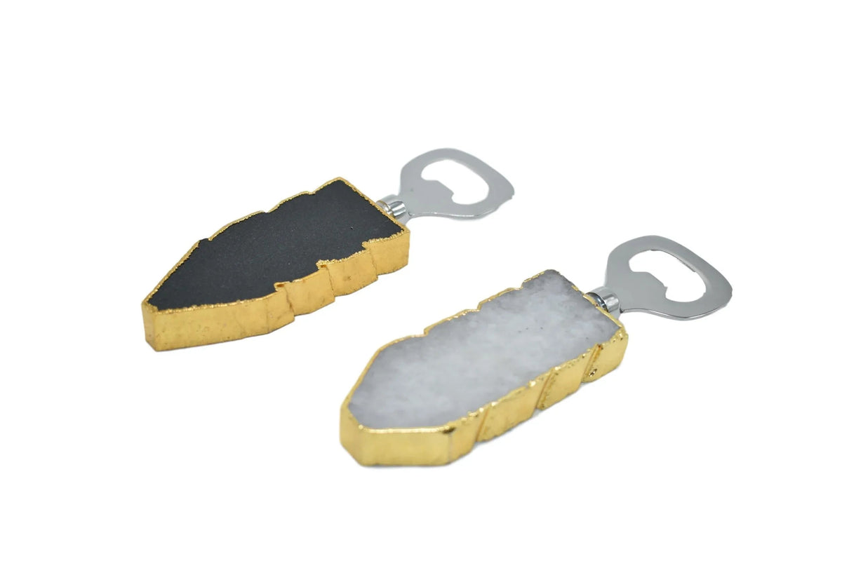 Close-up of black quartz bottle opener with gold trim on a white background.