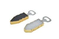 Close-up of black quartz bottle opener with gold trim on a white background.