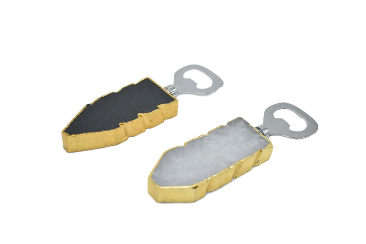 Close-up of black quartz bottle opener with gold trim on a white background.
