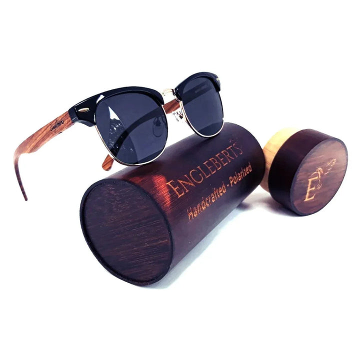 Real walnut wood club style sunglasses with polarized lenses placed next to bamboo case on white background.