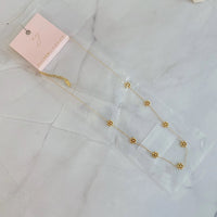 Close-up of necklace clasp and extender chain in gold finish on white background.