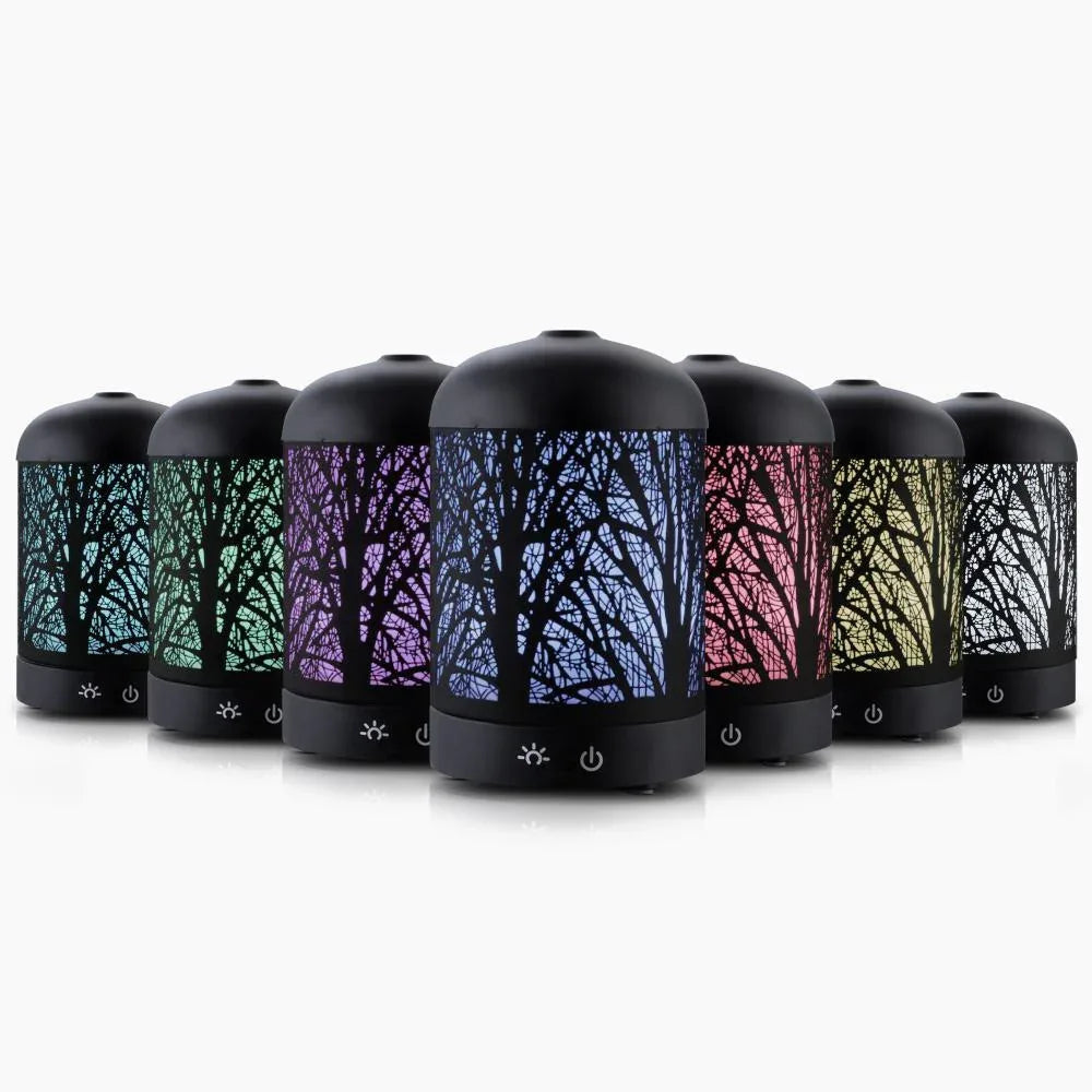 Black Devanti aroma diffuser with enchanted forest pattern on top, placed on wooden surface.