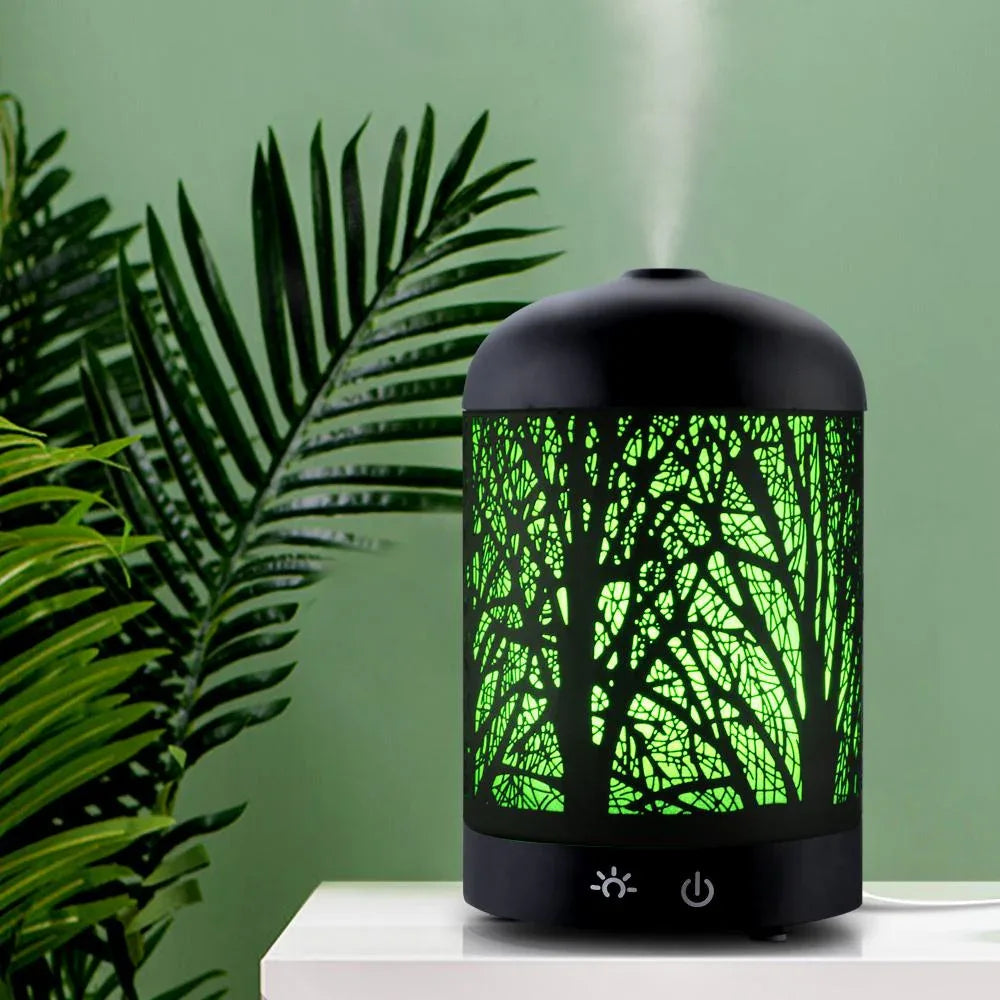 Black aroma diffuser on a table surrounded by various home accessories.