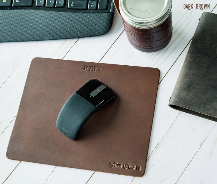 Dark brown genuine leather mouse pad with labeling showing material and features.