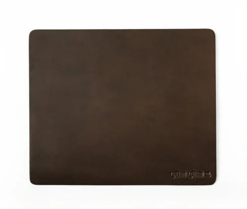 Top-down view of dark brown leather mouse pad highlighting grain texture.