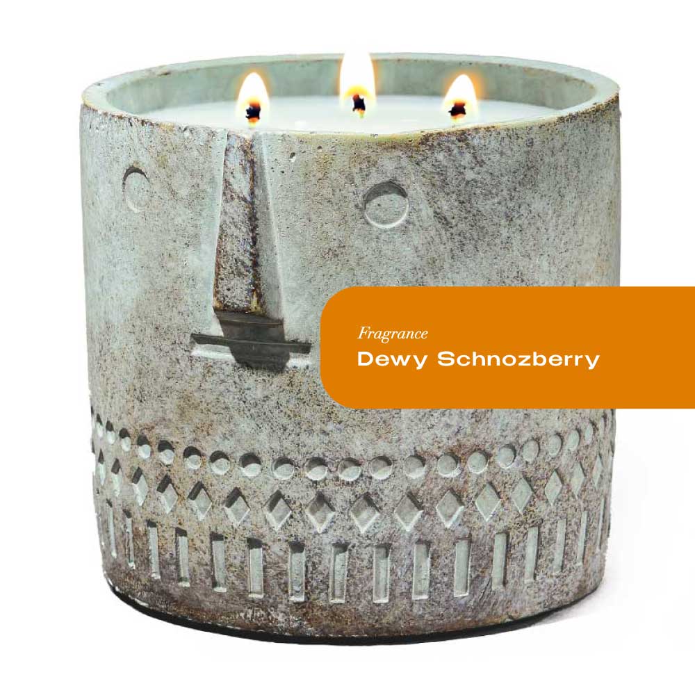 Large cement candle vessel shaped like a serene face with hand-painted details, 27oz Dewy Schnozberry Stone Candle.