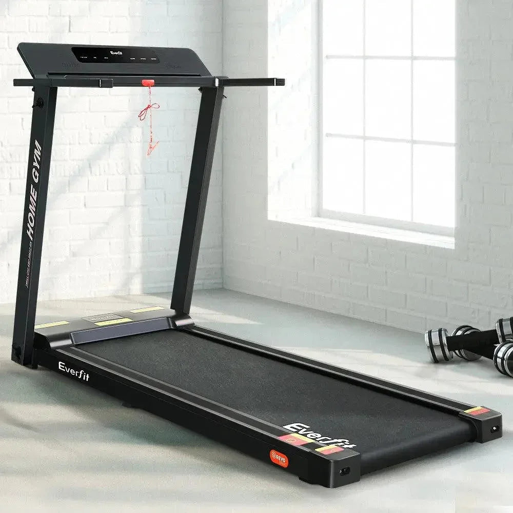 Treadmill in use inside home gym setting showing running belt and frame.