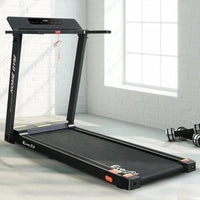 Treadmill in use inside home gym setting showing running belt and frame.
