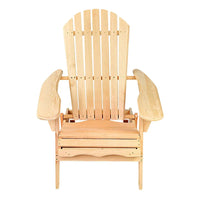 Folded wooden outdoor chair leaning against a rustic fence on summer day.