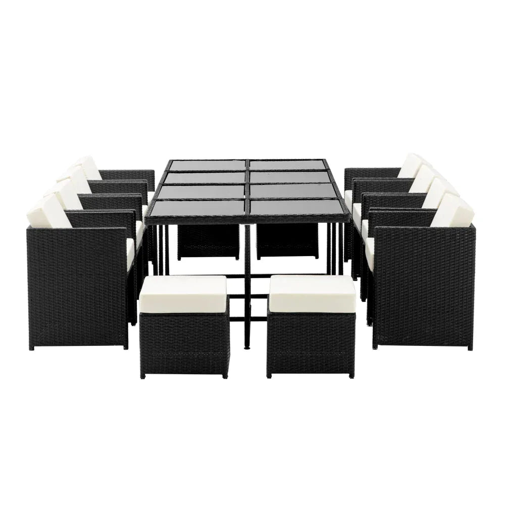 Side angle of the outdoor wicker dining set with chairs arranged around the table on stone tiles.