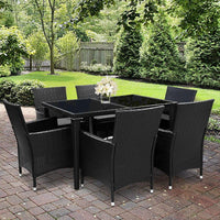 Protective water-resistant cover fully enclosing seven-piece outdoor dining set