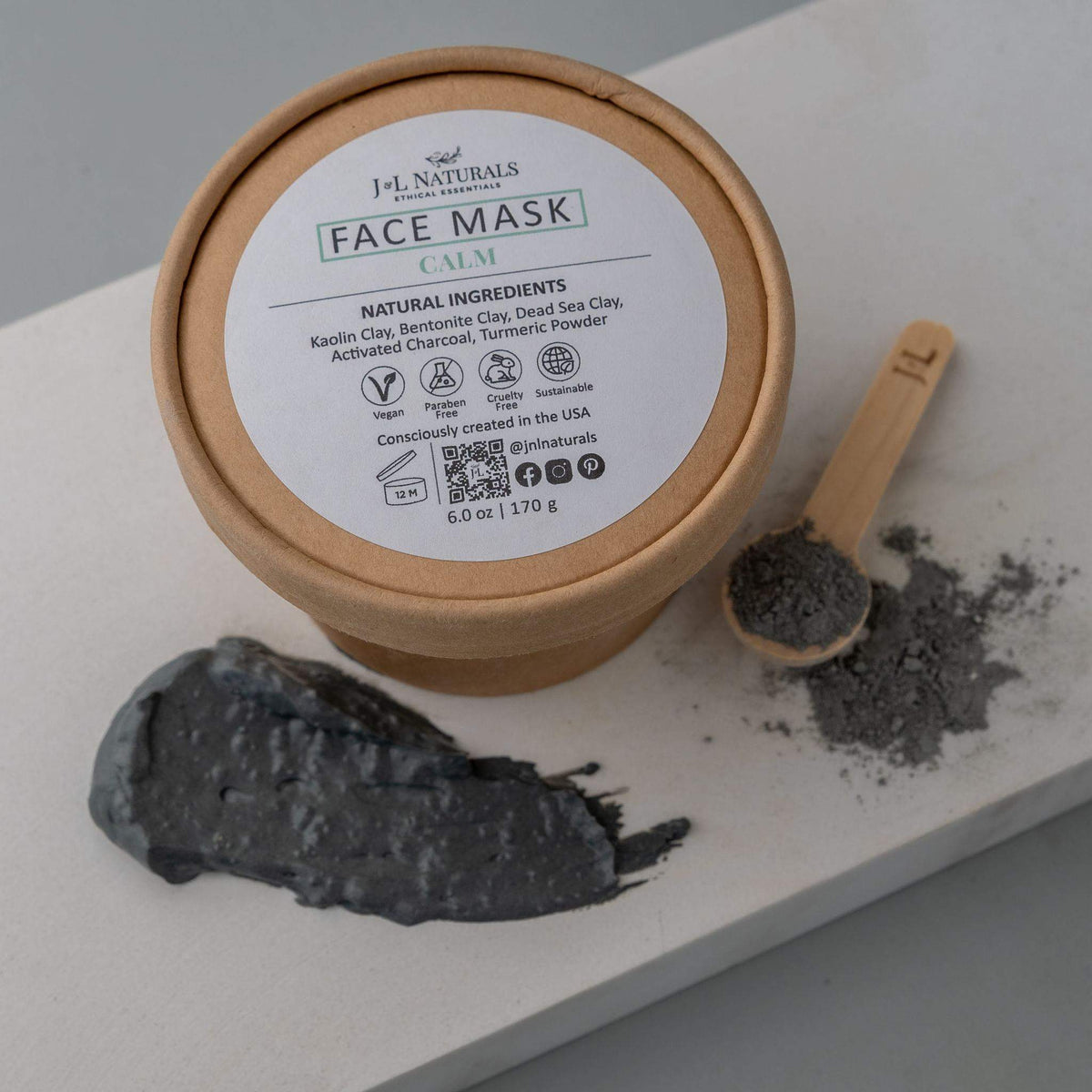 Close-up of calm face mask cream in jar surrounded by natural plants.