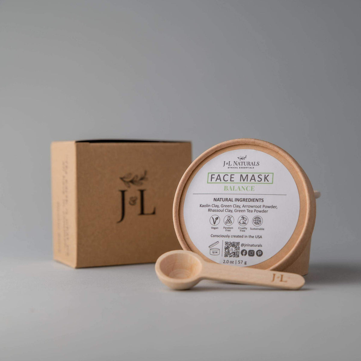 Close-up of creamy balance face mask spread on hand with natural ingredients around.