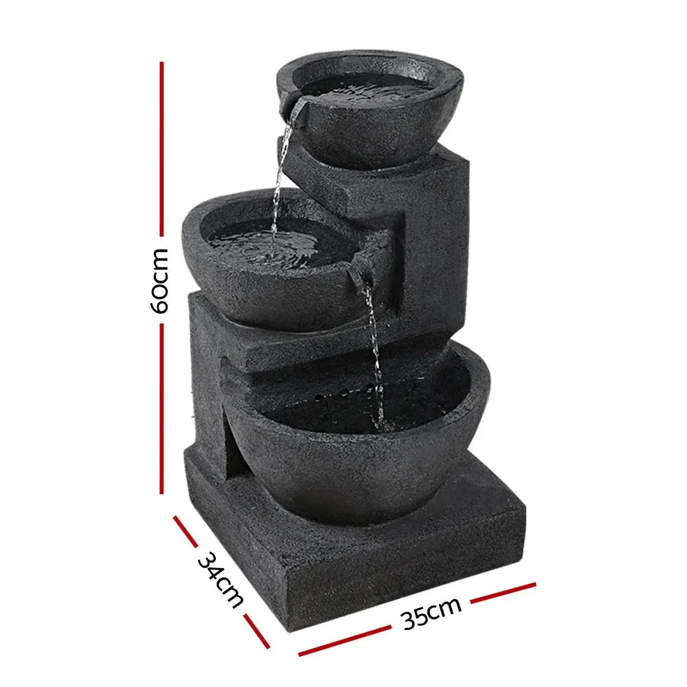 Close-up of blue three-tier solar bird bath fountain showing water cascading over edges
