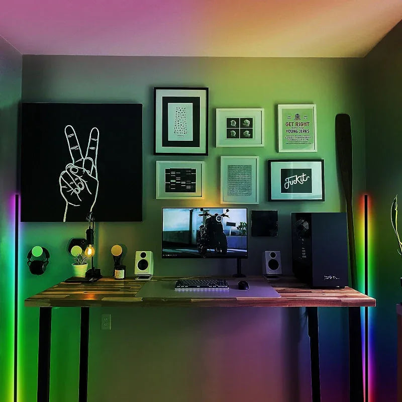 Minimalist black corner floor lamp lit in various RGB colors, creating ambient lighting.