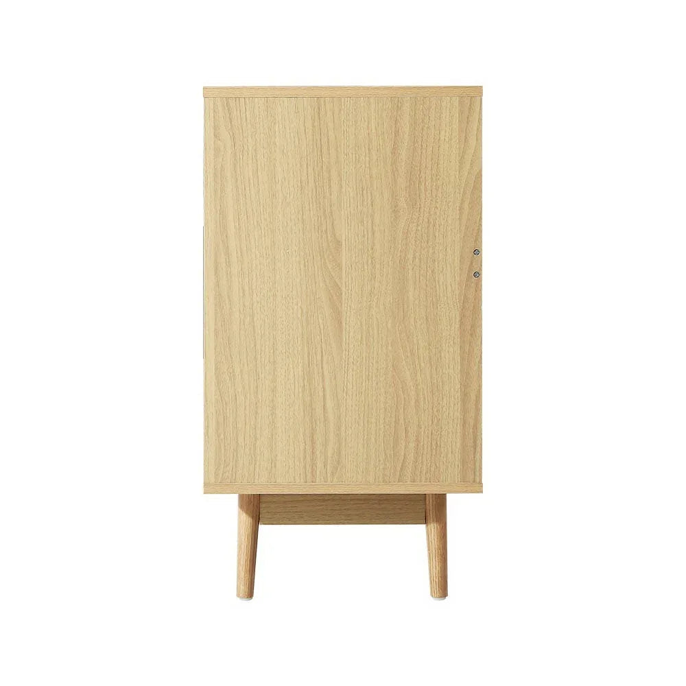 Opened drawer displaying storage space inside rattan chest of drawers.