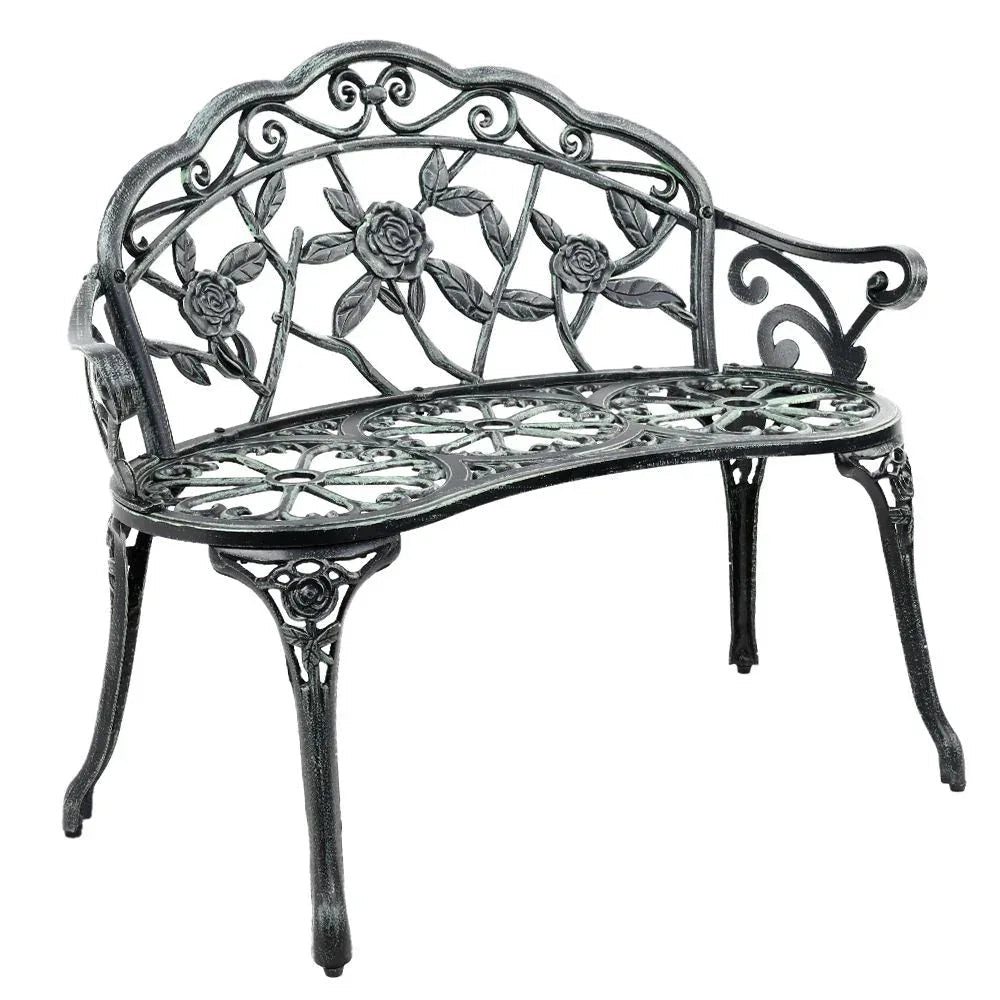 Green Victorian garden bench with ornate aluminum seat and floral backrest outdoors.