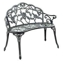 Green Victorian garden bench with ornate aluminum seat and floral backrest outdoors.