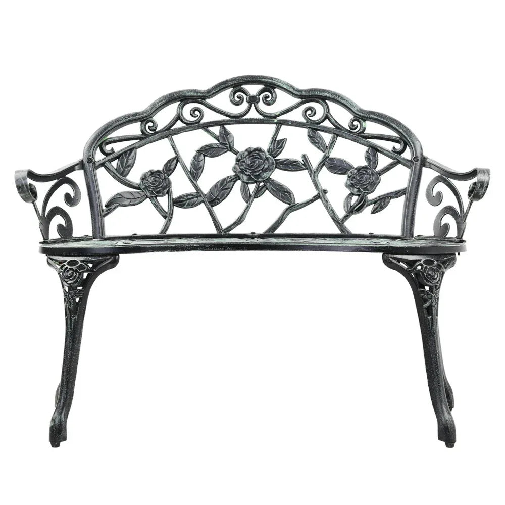 Close-up of floral-patterned backrest of green Victorian garden bench.