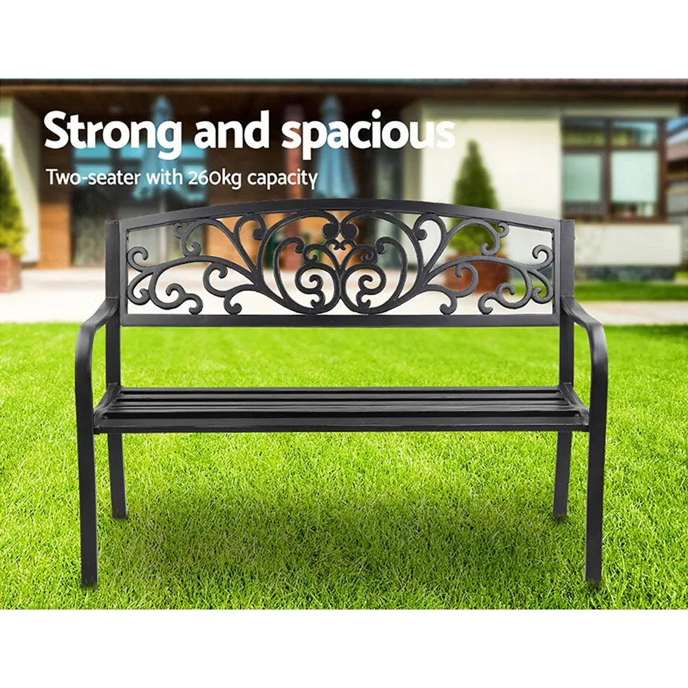 Close-up of powder-coated black iron legs of garden bench on concrete floor.