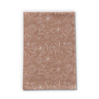Copper Magnolia Tea Towel displayed folded on a kitchen counter with soft natural light.