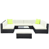 Top-down view of outdoor wicker patio lounge set with cushions and table