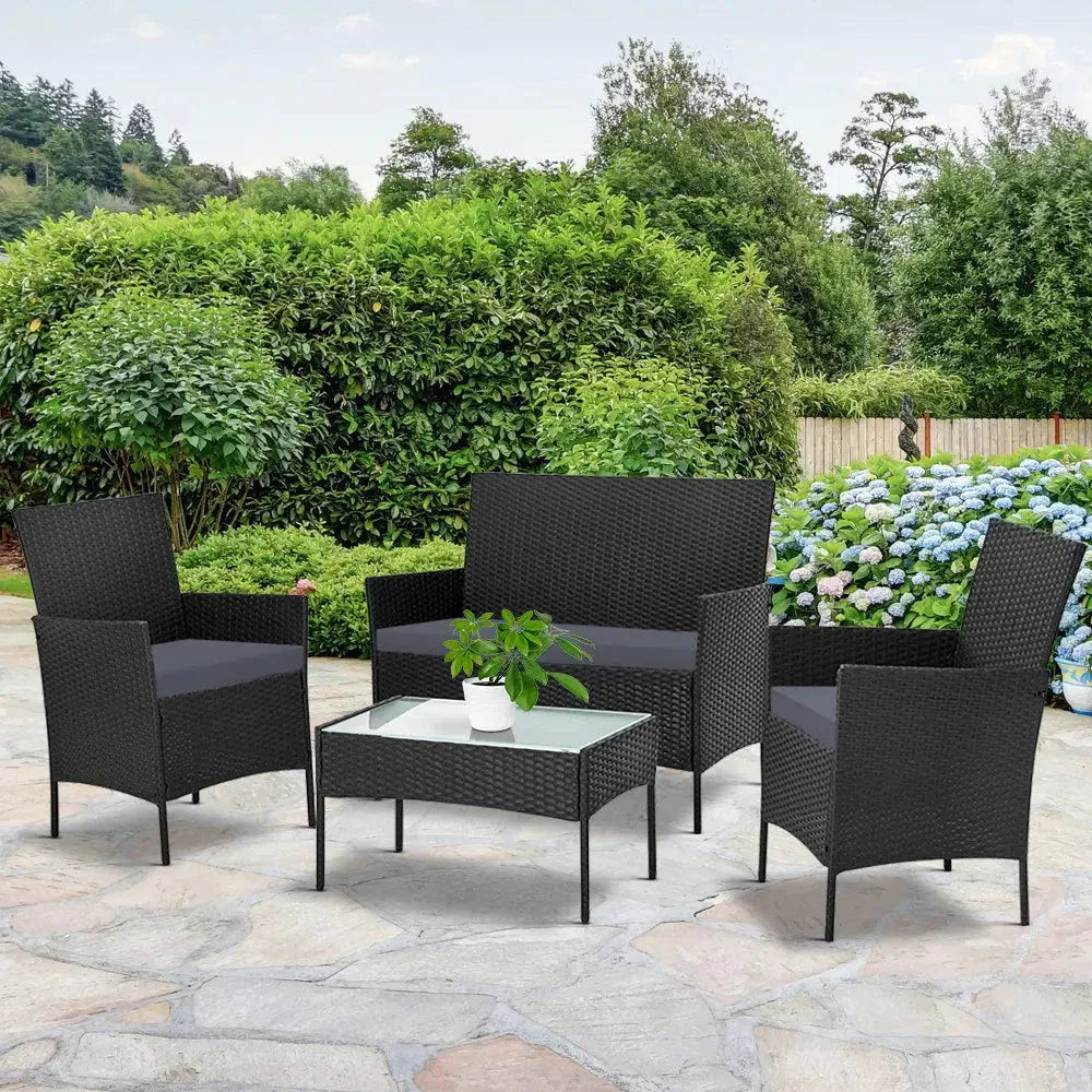 Full view of black protective cover encasing Gardeon garden wicker sofa set on patio.