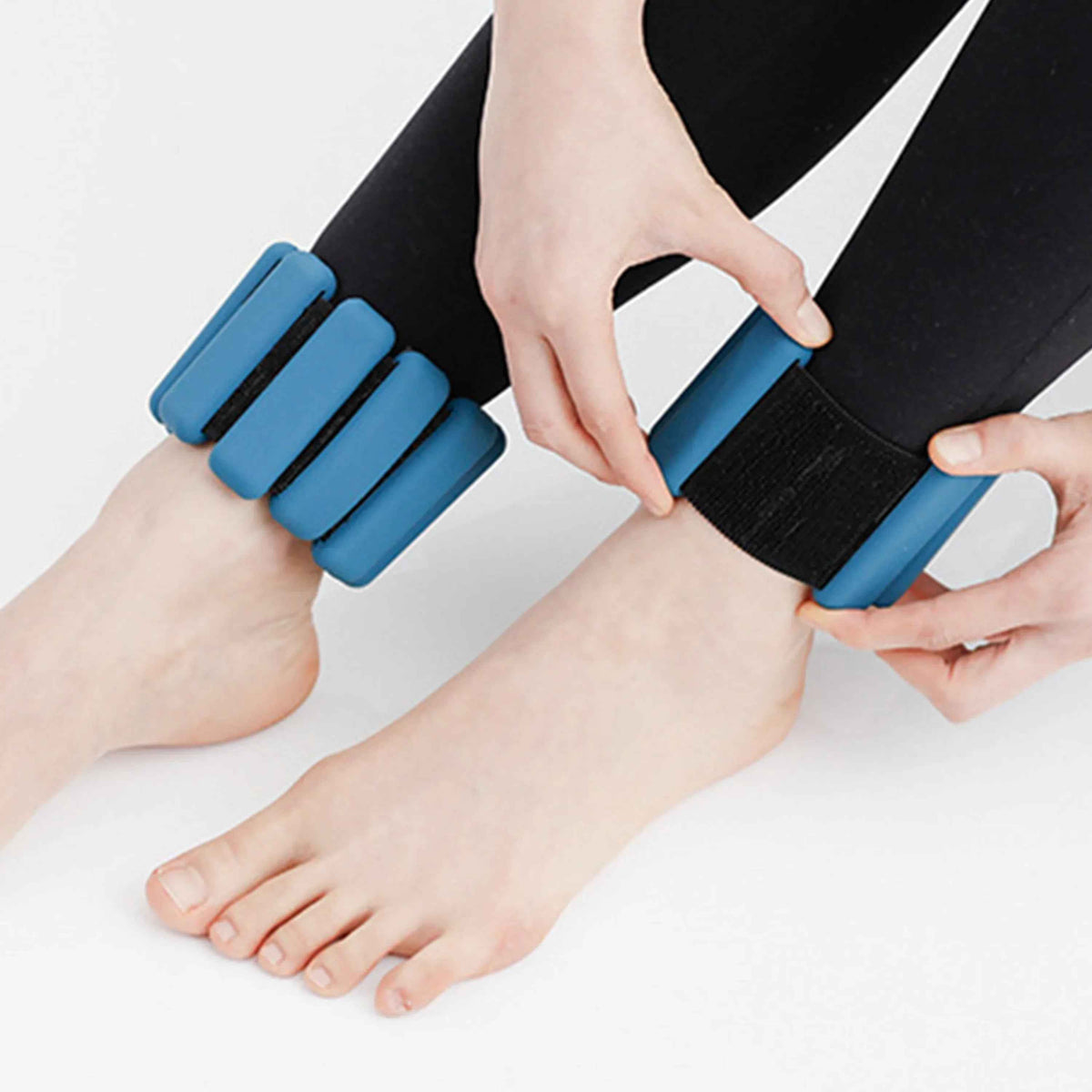 A pair of black silicone-coated wrist or ankle weights with adjustable Velcro straps, each weighing 1 pound.