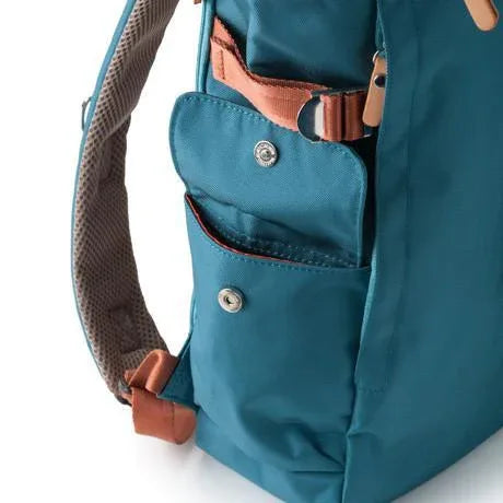 Back of blue rolltop backpack showing padded air mesh panel and D-ring attachments.
