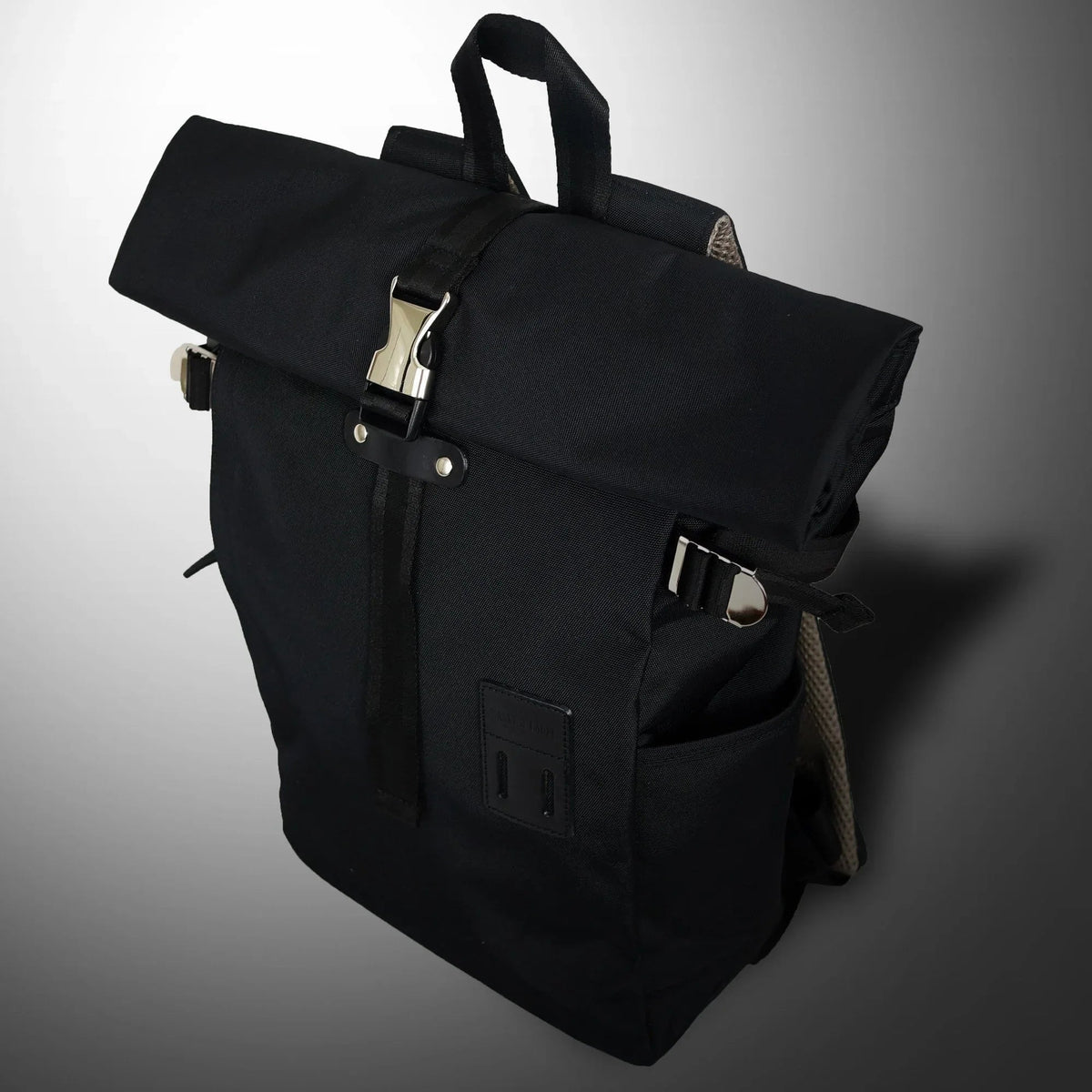 Blue rolltop backpack closed with visible top handle, on plain white background.