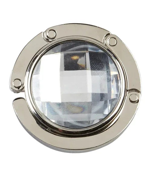 White handbag hanger with magnetic closure folded flat on white surface.