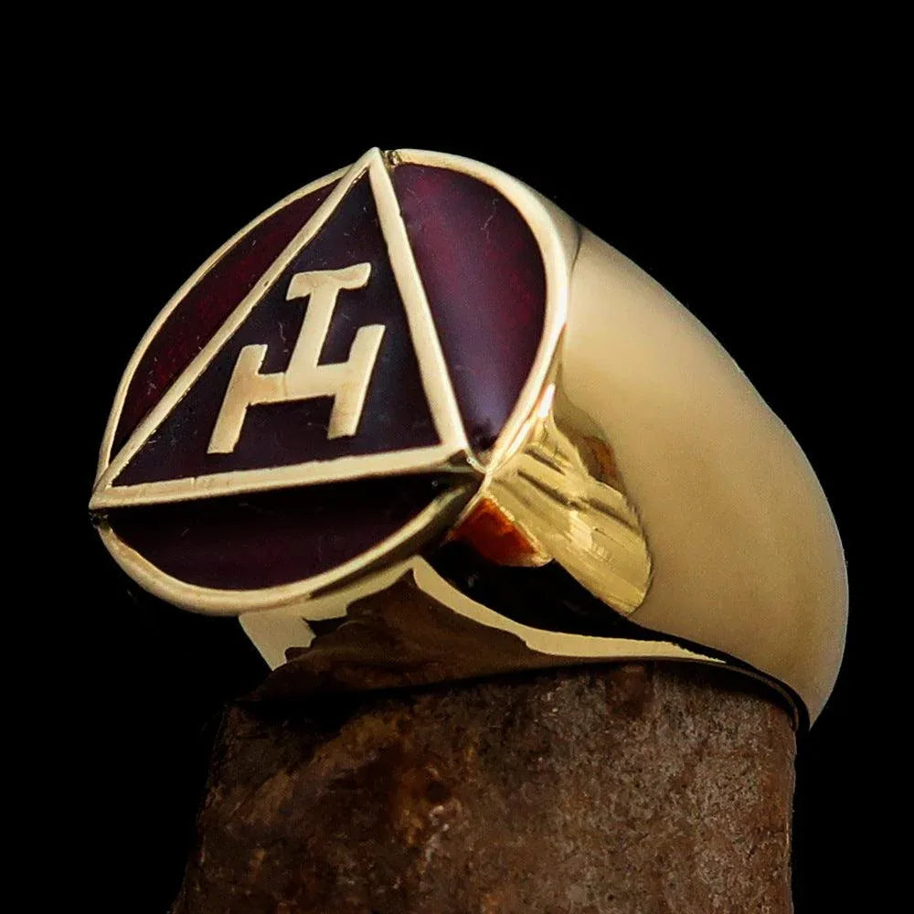 Hand wearing a polished solid brass red Masonic ring on the pinky finger.