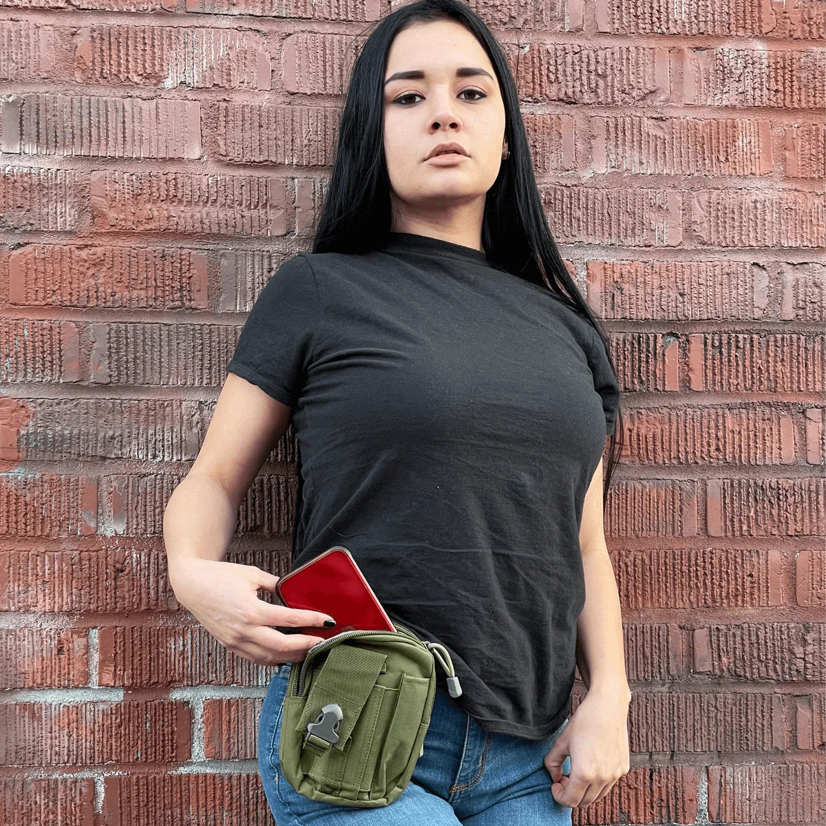 Side view of army green tactical MOLLE waist bag clipped on belt.
