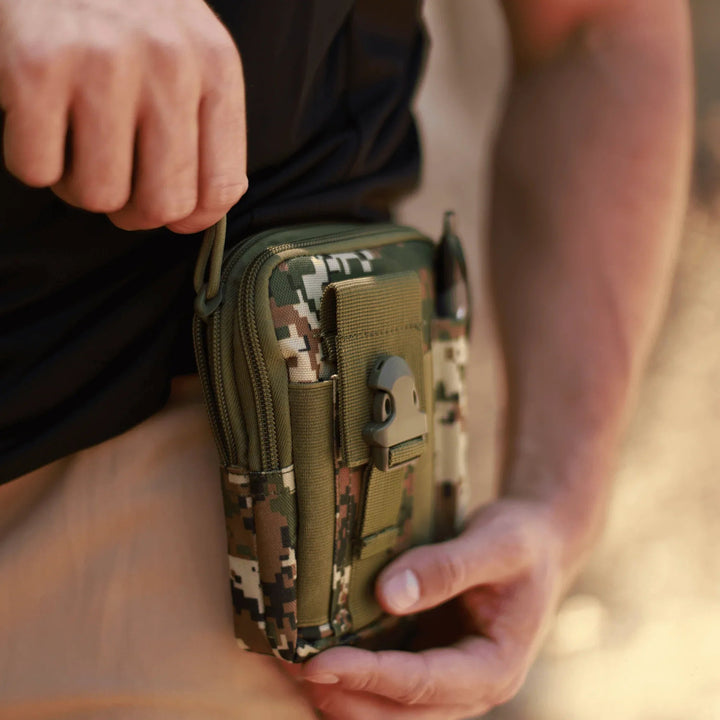 Black tactical MOLLE waist pouch with multiple compartments and durable straps laid flat on a gray background.