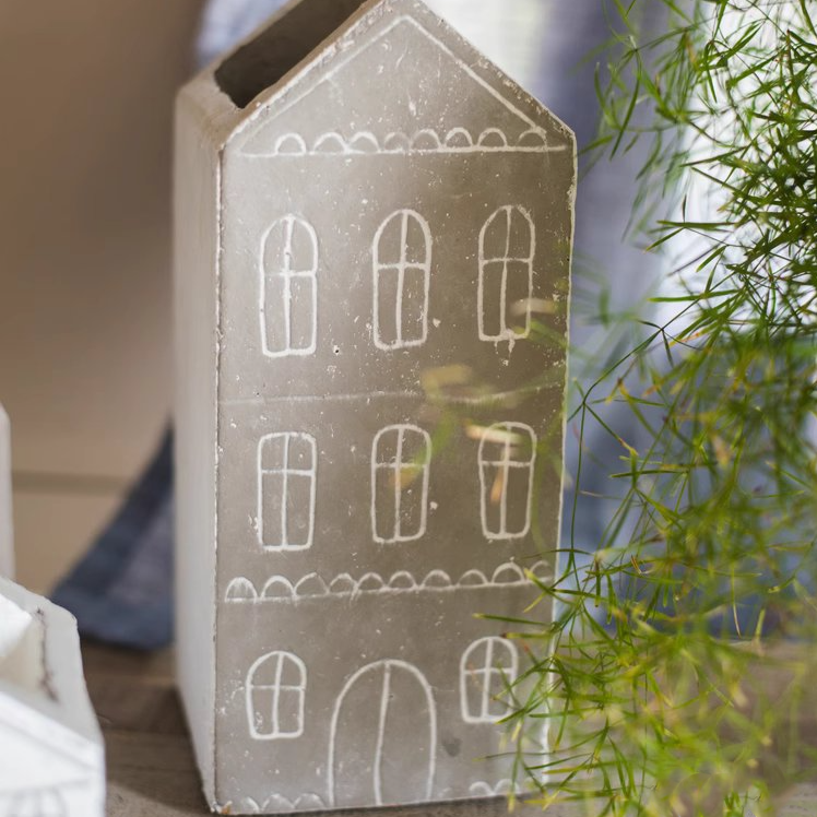 Black TinyHome Clay Planter next to small plant, displaying modern minimalist design.